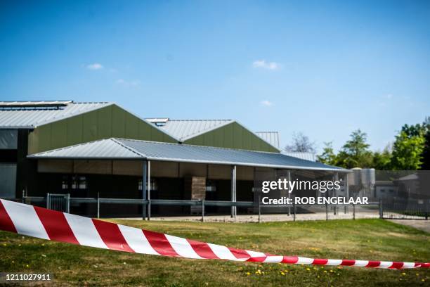 This general view shows barrier tape cordoning off buildings of a mink farm at Beek en Donk, eastern Netherlands on April 26 after tests showed that...