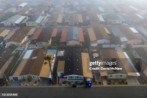 An aerial view shows a quiet neighborhood on a foggy morning as residents continue to stay at home to fight the coronavirus pandemic on April 26,...