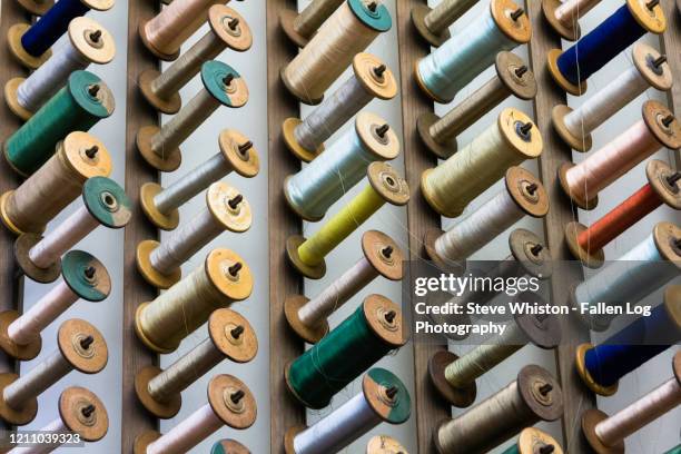 colorful and abstract patterns of different colored spools of sewing threads on display - changing form stock pictures, royalty-free photos & images