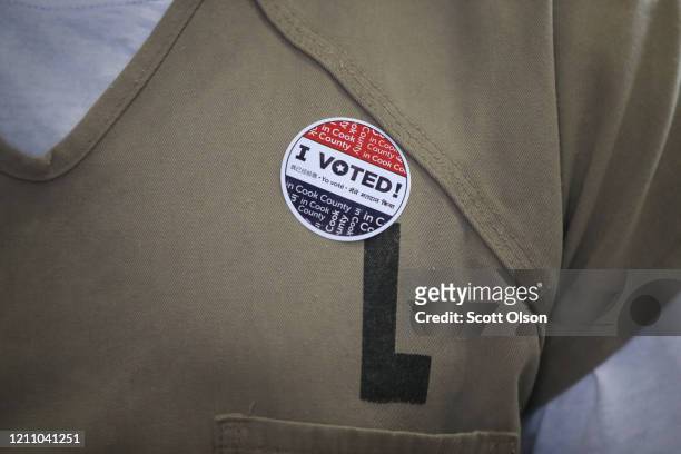 An inmate at the Cook County Jail wears an "I Voted" sticker after voting in the Illinois primary election when a polling place in the facility was...