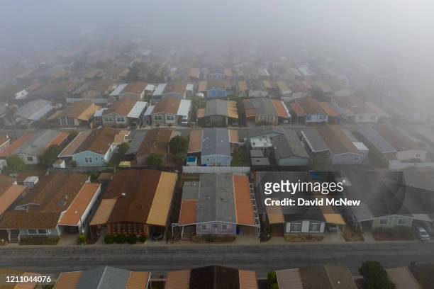 An aerial view shows a quiet neighborhood on a foggy morning as residents continue to stay at home to fight the coronavirus pandemic on April 26,...