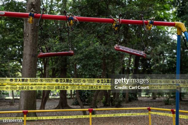 Tape is placed around swings that have been closed off to protect against the spread of Covid-19 coronavirus in a childrens play area in Kinuta Park...