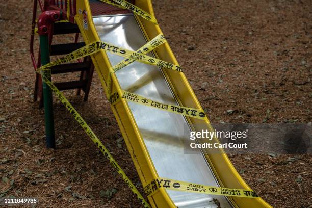 Tape is placed around a slide that has been closed off to protect against the spread of Covid-19 coronavirus in a childrens play area in Kinuta Park...