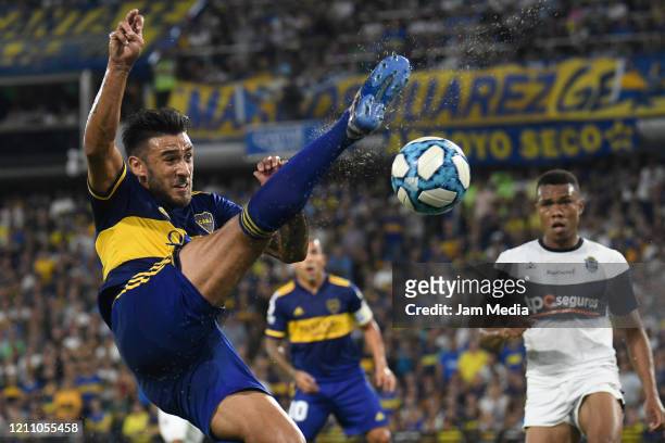 Eduardo Salvio of Boca Juniors kicks the ball against Harrinson Mancilla of Gimnasia y Esgrima during a match between Boca Juniors and Gimnasia y...