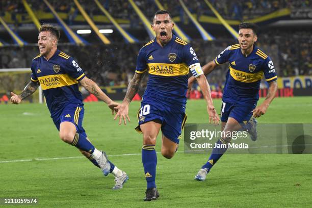 Carlos Tevez of Boca Juniors celebrates with teammates Julio Buffarini and Eduardo Salvio after scoring the first goal of his team during a match...