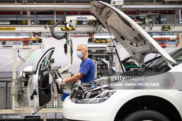 An employee of German car maker Volkswagen works on the assembly line of the company's plant in Wolfsburg, northern Germany, after production at the...