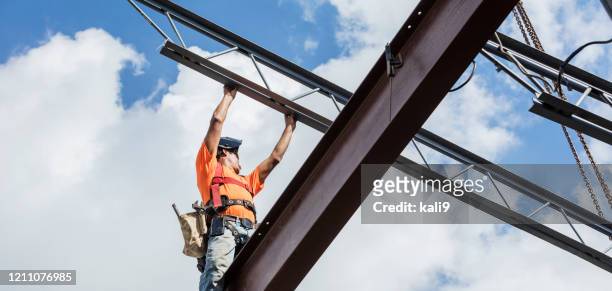 ironworker at construction site installing roof joist - arms of steel stock pictures, royalty-free photos & images