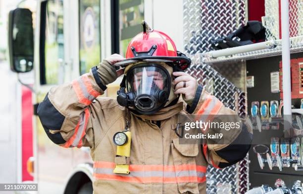 firefighter in fire protection suit and respirator mask - firefighter getting dressed stock pictures, royalty-free photos & images