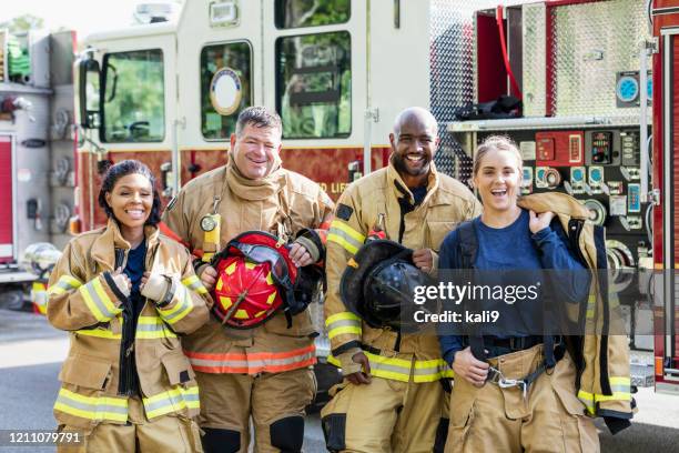 equipe de bombeiros parada na frente de caminhão de bombeiros - roupa a prova de fogo - fotografias e filmes do acervo