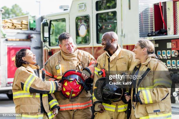 team von feuerwehrleuten steht vor feuerwehrauto - feuerwehrmann stock-fotos und bilder