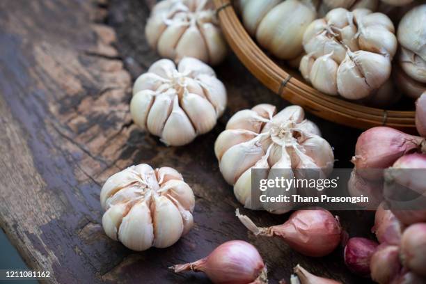 close-up of garlic and onions in wicker basket - garlic ストックフォトと画像