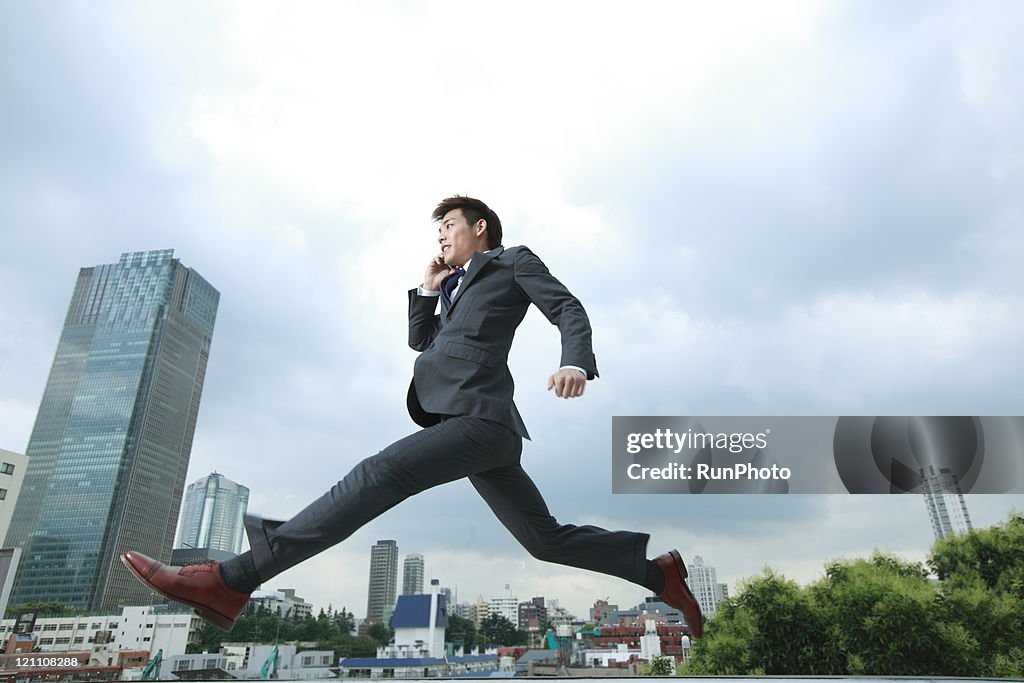 Business man jumping in city
