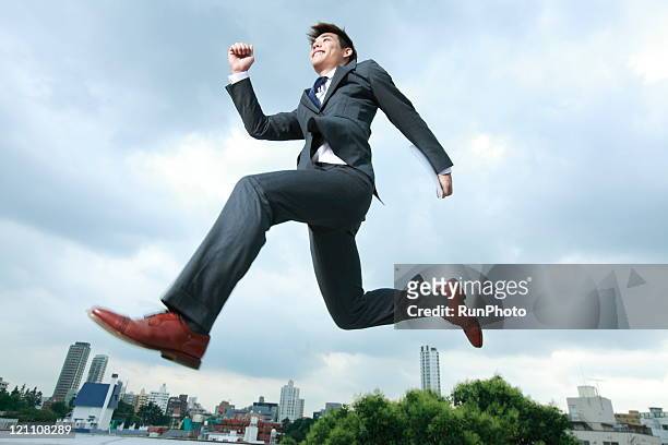 business man jumping in city - running midair stock pictures, royalty-free photos & images