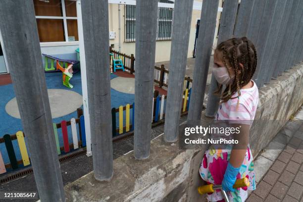 Girl watches some swings the first day children go out into the street after 42 days of confinement due to the mandatory quarantine decreed by the...