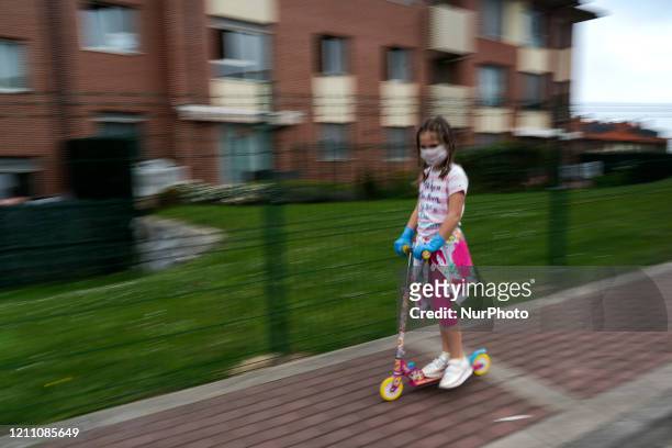 Girl plays with her scooter during the first day that children are released again after 42 days confined by the mandatory quarantine decreed by the...