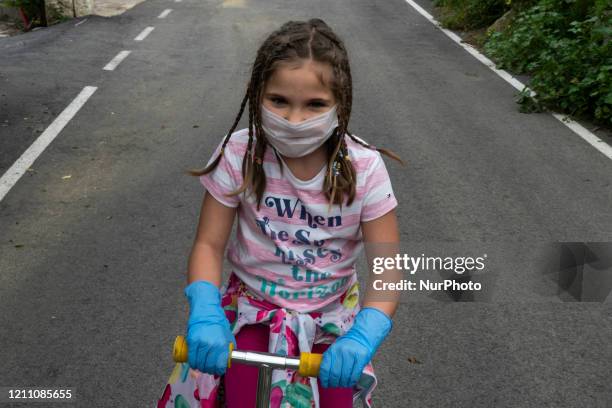 Girl plays with her scooter during the first day that the children are allowed to go out again after 42 days of mandatory quarantine decreed by the...