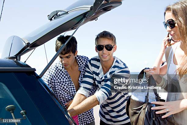 friends packing the car by the sea. - four people in car fotografías e imágenes de stock