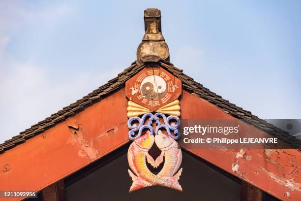 yin and yang symbol and fish decoration on a taoist temple roof - tao stock-fotos und bilder