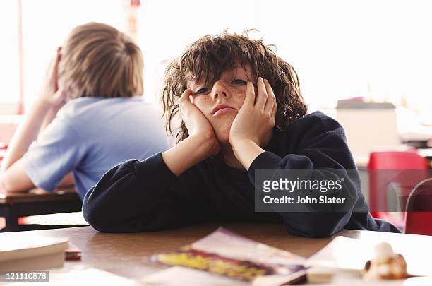 portrait of schoolboy looking bored - bores stock pictures, royalty-free photos & images