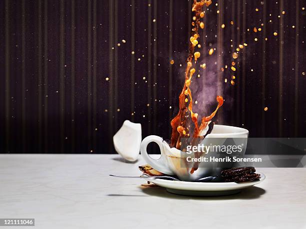 tea cup shattering on table - broken cup stock-fotos und bilder
