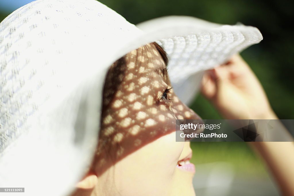 Young woman wearing a straw hat,profile