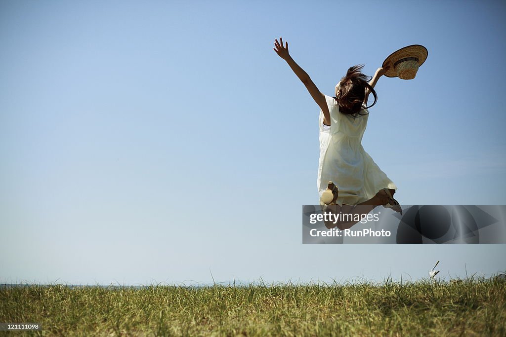Young woman jumping under the sun