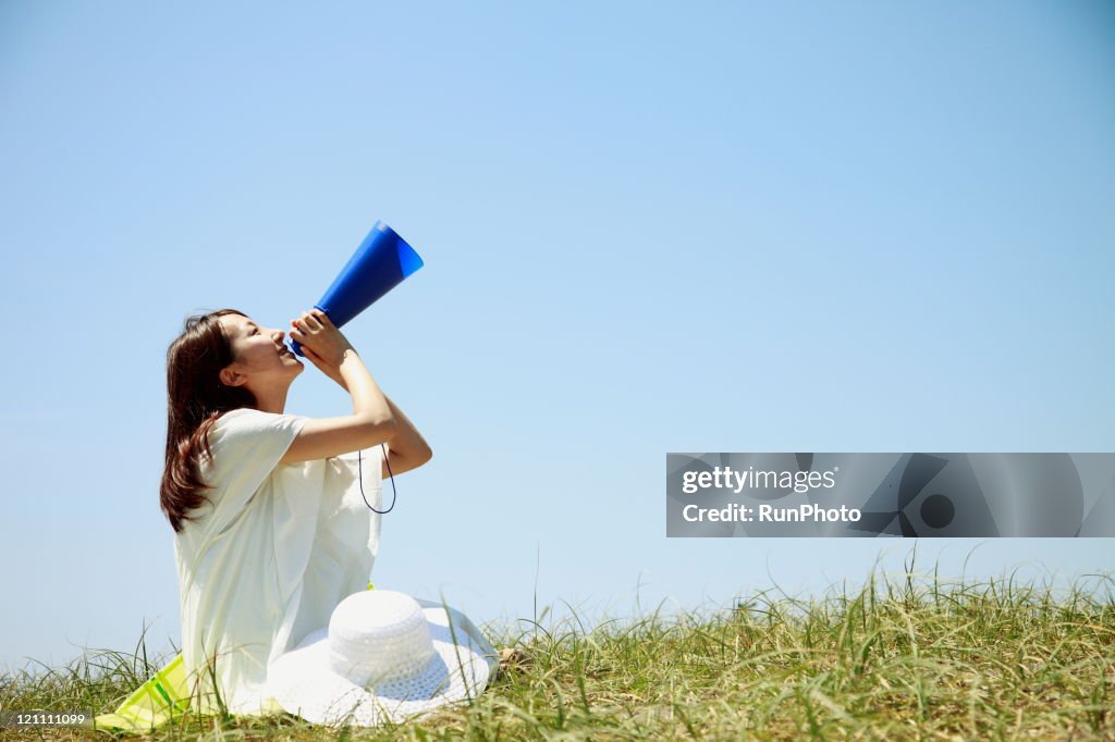 Young woman with a megaphone to cheer