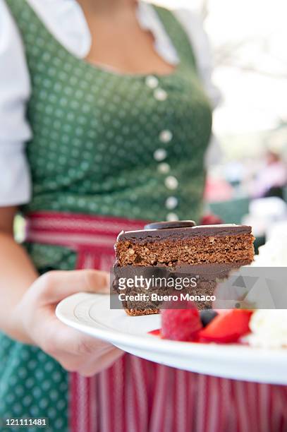 waitress in traditional dress serving sacher cake - sachertorte stock pictures, royalty-free photos & images