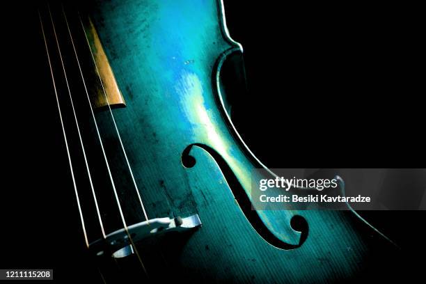 Cello in aqua menthe on dark background.