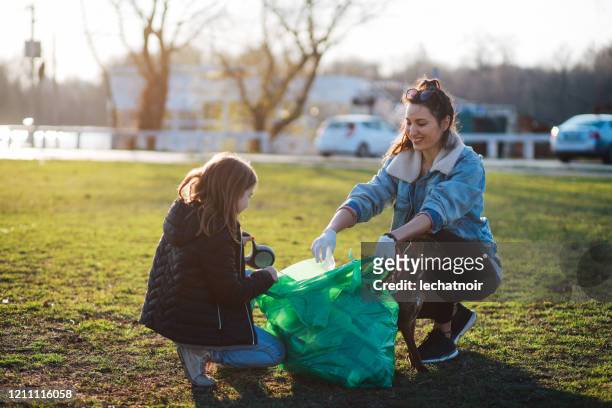 媽媽和女兒清潔塑膠垃圾 - city cleaning 個照片及圖片檔