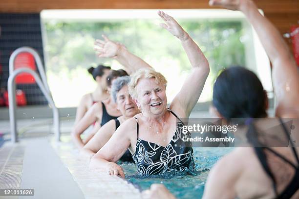 mature women doing aquacise in pool - aquarobics stock-fotos und bilder