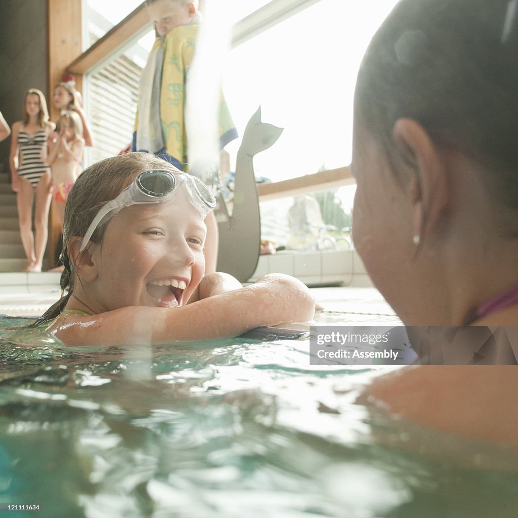 Tween girls laugh in pool