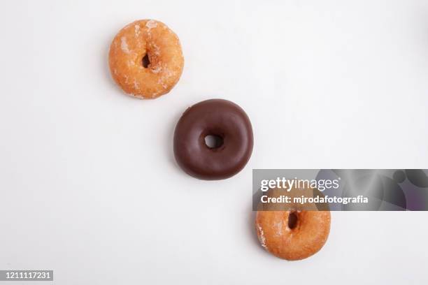overhead view of donuts against white background - buñuelo en forma de rosca fotografías e imágenes de stock