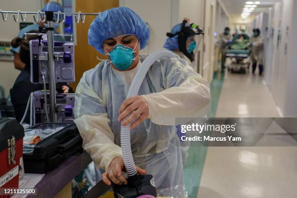 Respiratory therapist Sandra Sandoval prepares her PAPR, a battery-powered blower that provides positive airflow through a filter, as a patient with...