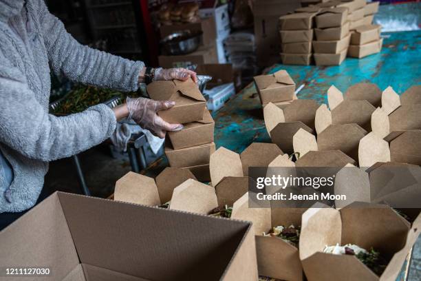 Kopitiam Co-owner Moonlynn Tsai holds lunch boxes to donate to a hospital in Manhattan on April 27, 2020 in New York City. Many restaurants are...