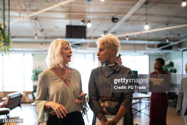 business partners walking at break time at lobby - corporate gender equality stock pictures, royalty-free photos & images