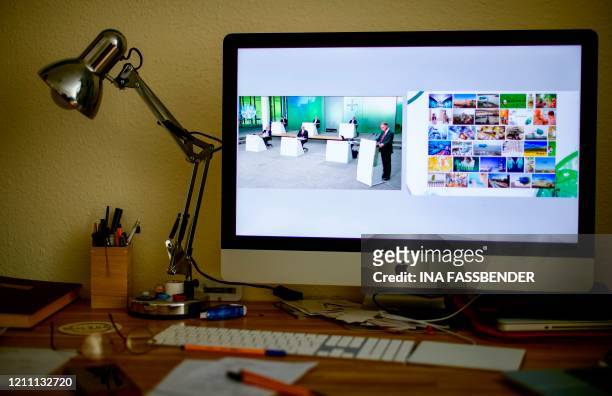 The CEO of German chemicals giant Bayer, Werner Baumann is displayed on a computer screen during his speech of the group's online annual general...