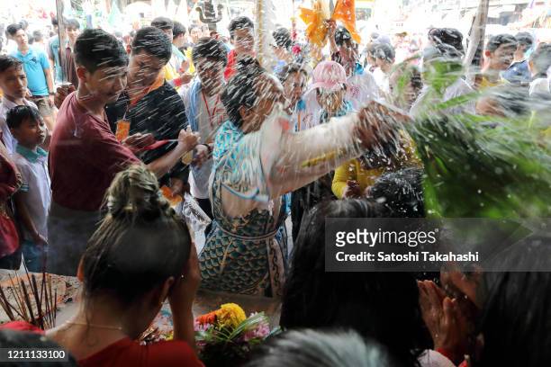 Spirit medium splashes holy water while in a state of trance during a ritual of Hei Neak Ta or Spirit Parade to mark the end of Chinese New Year...