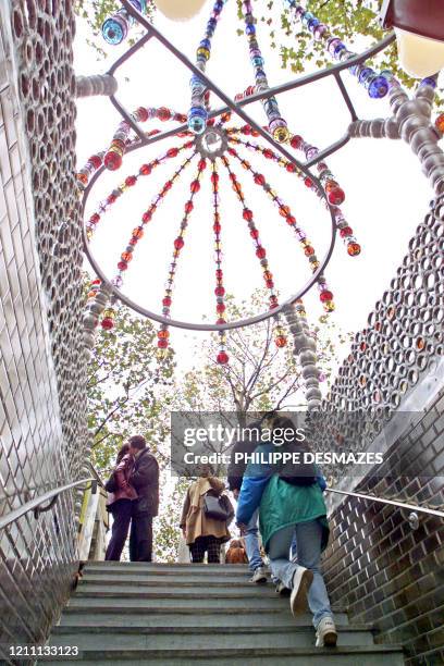 Metro commuters step out of the Palais Royal underground station in central Paris 31 october 2000, which is adorned by glass and aluminium balls set...