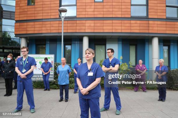 Staff stand outside Salford Royal Hospital in Manchester during a minute's silence to pay tribute to the NHS staff and key workers who have died...