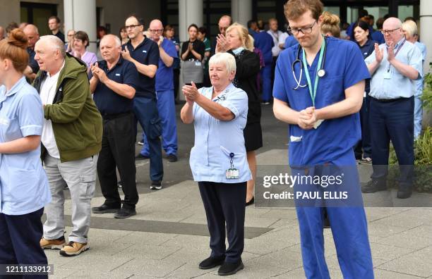 Staff applaud after pausing for a minute's silence to honour UK key workers, including NHS staff, health and social care workers, who have died...