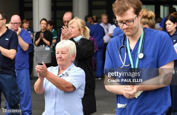 Staff applaud after pausing for a minute's silence to honour UK key workers, including NHS staff, health and social care workers, who have died...