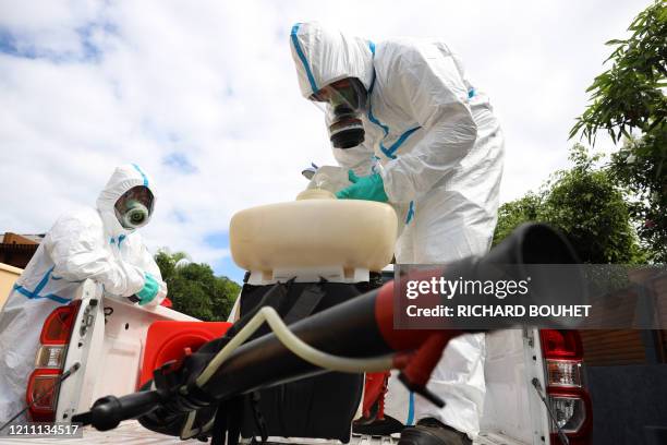 Workers of the vector control team of the French Indian Ocean island of La Reunion departmental fire service and regional public health authorities...