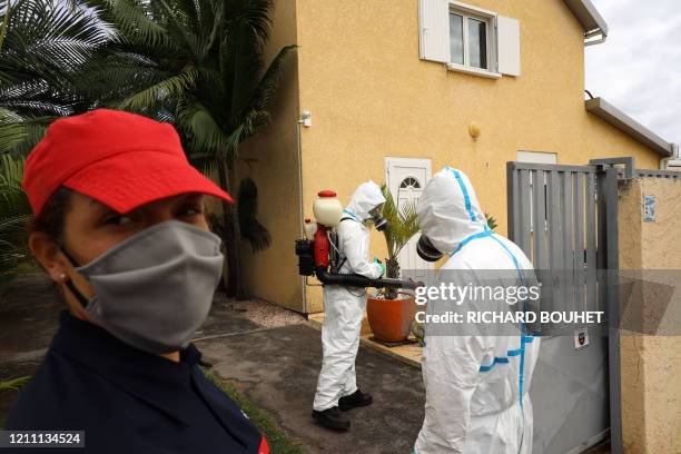 Workers of the vector control team of the French Indian Ocean island of La Reunion departmental fire service and regional public health authorities...