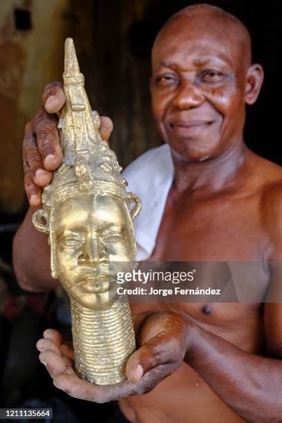Craftsman showing a bronze statuette made using the technique of lost wax casting, used in the kingdom of Benin before the European colonizers...