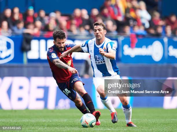 Victor Sanchez of RCD Espanyol duels for the ball with Ruben Garcia of CA Osasuna during the Liga match between CA Osasuna and RCD Espanyol at El...