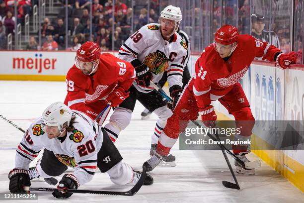 Sam Gagner and Valtteri Filppula of the Detroit Red Wings battles along the boards with Jonathan Toews and Brandon Saad of the Chicago Blackhawks...