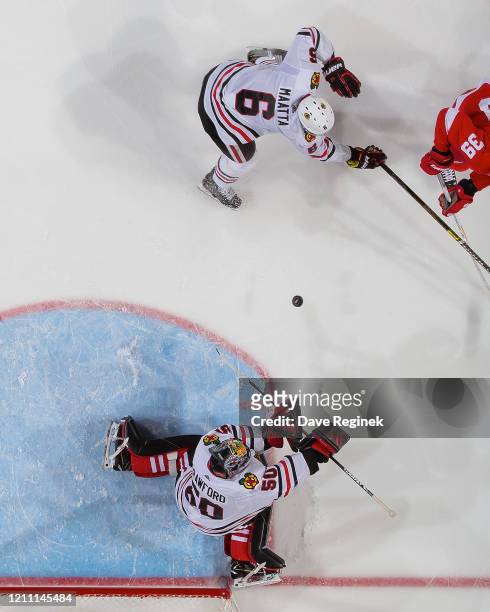 Corey Crawford of the Chicago Blackhawks makes a save as teammate Olli Maatta defends in front against the Detroit Red Wings during an NHL game at...