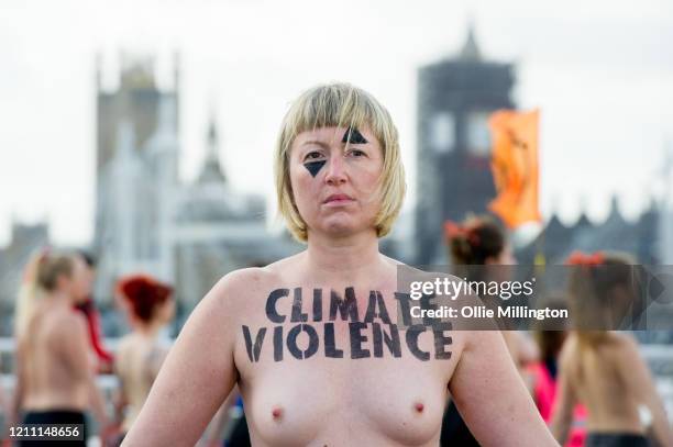 Female members of the Extinction Rebellion Climate Crisis activist group protest topless while blocking all traffic from using Waterloo Bridge during...