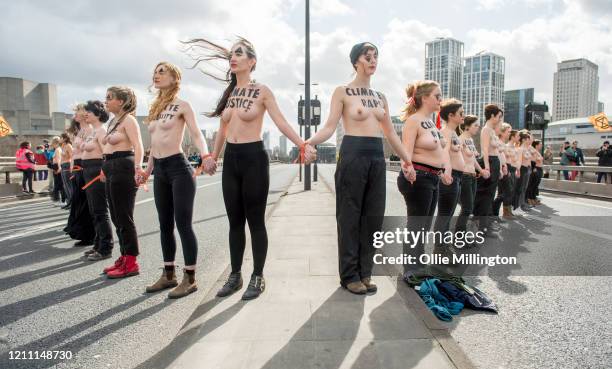 Female members of the Extinction Rebellion Climate Crisis activist group protest topless while blocking all traffic from using Waterloo Bridge during...